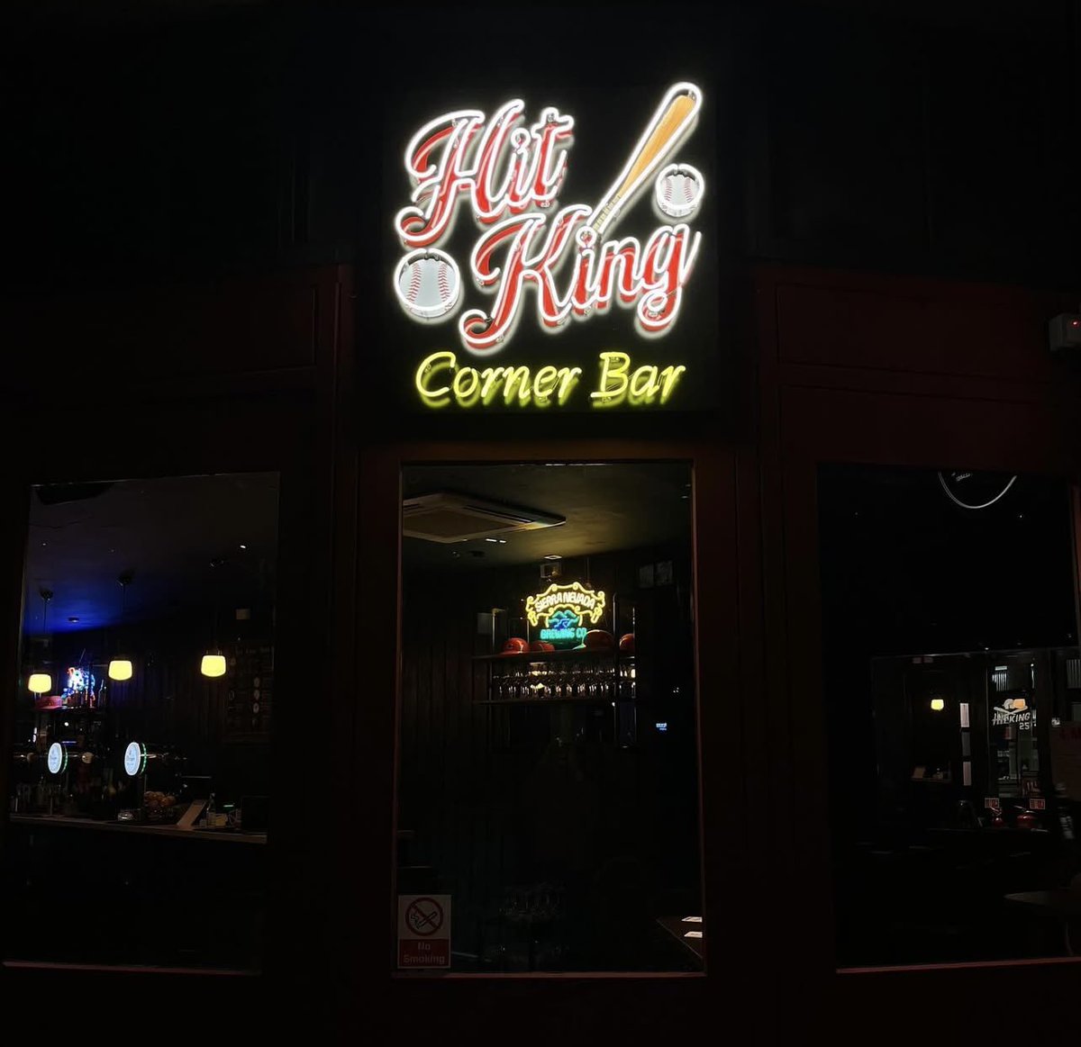Hit King Corner Bar neon sign glowing at night in Aldgate